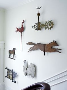 the wall is decorated with metal animals and other decorative items, including horse figurines