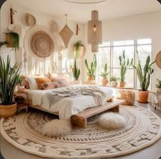 a bed room with a neatly made bed and lots of potted plants