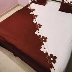 a bed with red and white bedspread on top of it