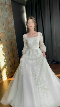 a woman in a white wedding dress posing for the camera