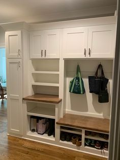 a room with some white cabinets and wooden shelves on the wall next to a door