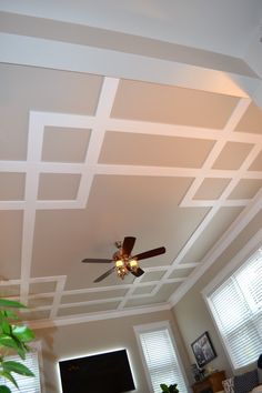 a living room with a ceiling fan and windows