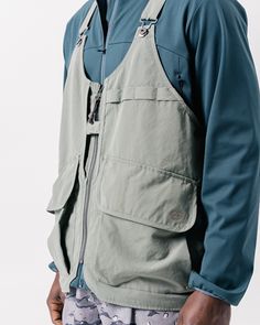 The Takibi Weather Cloth Vest is a fire-resistant utility vest. The vest features adjustable straps with metal buckle closures, a zip front with a chest snap, dual oversized pouch pockets with hook-and-loop secured envelope flaps, dual side loops, oversized back storage pouches, and an additional storage loop at the curved hem. The Takibi Vest is designed to fit loose on the body with the hem hitting below the waist. We recommend taking your normal size for an oversized fit. The model stands 6' Utility Accessories, Gorpcore Vest, Camping Vest, Vest Pattern Free, Sewing Projects Clothes, Outdoor Vest, Utility Vest, Safety Vest, Vest Designs