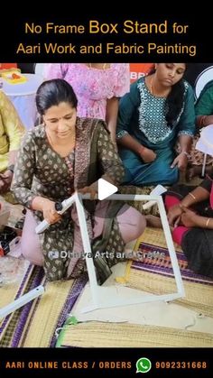 a group of women sitting around each other working on some art work with scissors and paper