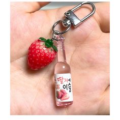 a bottle with a strawberry on it is being held by a person's hand