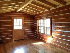 an empty room with wood paneling and windows