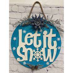 a sign that says let it snow hanging on a brick wall