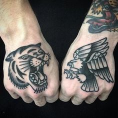 two hands with black and white tattoos on them, one has an eagle and the other has a tiger