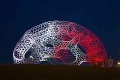 an artistic sculpture is lit up at night