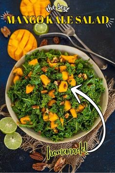 kale mango salad in a bowl with limes and nuts