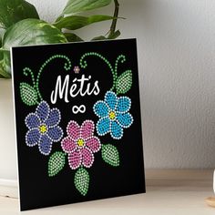 a black card with colorful flowers and the words mets on it art board print