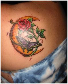 a woman's stomach with a rose and butterfly tattoo on it