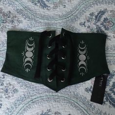 Nwt Dark Cottage Selene Corset Belt In A Ladies Size 2xl. This Is A Lovely Shade Of Forest Green With The Moon Phases Embroidered On It In Silver. It Comes With A Stretchy Velvety Black Ribbon. The Design Of This Garment Is Very Adjustable To Accommodate Everyday Weight Fluctuations. Made From 100% Cotton And Is Machine Washable. This Is A Versatile Piece And Would Be A Great Addition To A Ren Faire Costume, For Larping, Or Just For Everyday If That Is Your Style. This Is In Excellent Nwt Condit Renn Faire Accessories, Green Witch Fashion, Green Goth Aesthetic, Witchy Closet, Moon Corset, Dark Corset, Elven Fashion, Dnd Oc, Goth Fits