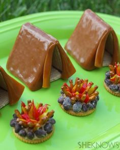 small chocolate houses are sitting on a green plate