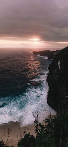 an ocean view with waves crashing on the shore