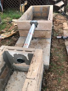 a concrete block with a pipe sticking out of it's center in the ground