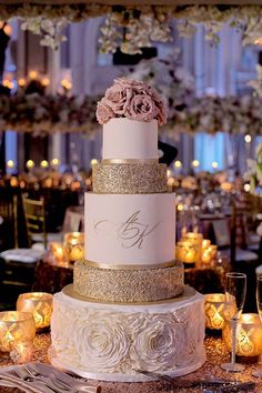 a white and gold wedding cake sitting on top of a table