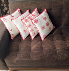 three pillows on a couch with snowflakes