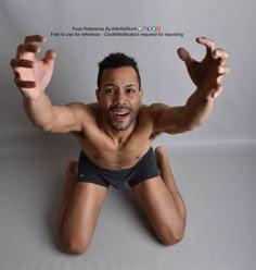 a man with no shirt is posing for the camera and has his arms stretched out