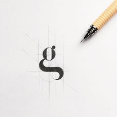 a pen is sitting on top of a piece of paper with the letter s in it