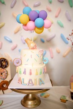 a birthday cake with balloons and confetti on top