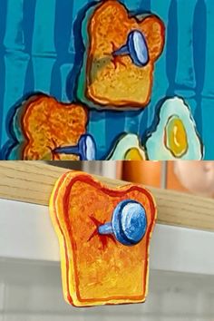 a piece of toasted bread with blue buttons on it and an image of a cartoon character in the background