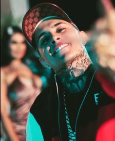 a young man with tattoos on his face and head is smiling at the camera while other people stand behind him