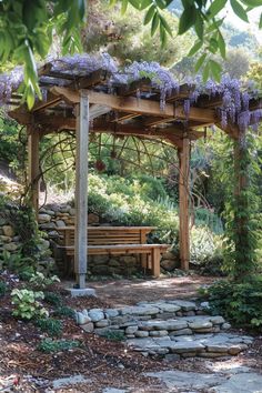 a wooden bench sitting under a pergoline covered arbor in the middle of a forest