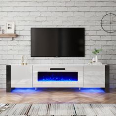 a white entertainment center with blue flames on the side and a flat screen tv mounted above it