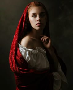 a woman with red hair wearing a red shawl