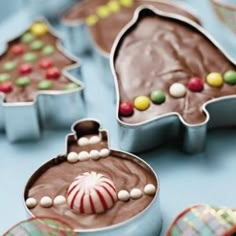 some kind of chocolate christmas tree cookie cutters on a blue table with candy and candies