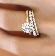 a woman's hand with two rings and a diamond ring on top of her finger