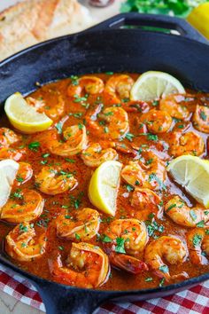 a skillet filled with shrimp and lemon slices