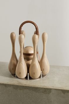 a group of wooden bowling pins sitting on top of a cement counter next to a basket