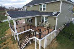 an aerial view of a two story house with deck and stairs leading up to the second floor