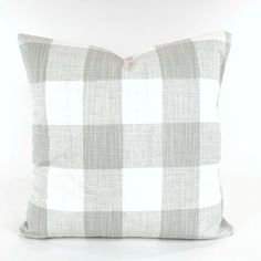 a gray and white checkered pillow on a white background