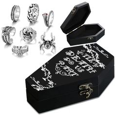 an open box with six rings in it next to other jewelry items on a white background