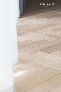 a white vase sitting on top of a hard wood floor next to a tall column