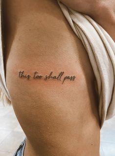 a woman with a tattoo on her back saying, this too shall pass the word is written in cursive font