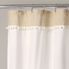 a white shower curtain with pom - poms on it