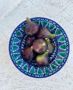 some figs are in a blue and green bowl