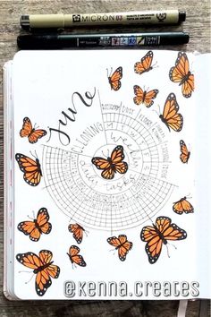 an open notebook with butterflies on it and the words june written in black ink next to a pencil