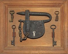 an old lock and some keys in a wooden frame