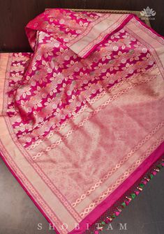 A magnificent saree from the Banarasi repertoire that showcases its finery! A new design with rose creepers colored in meenakari silk form a standout design! Set in a lovely Pink dual Tone shade, the motifs beautifully stand out against the dark base! The base fabric is pure Katan silk which is known for its luster and softness! SILK MARK CERTIFIED The saree is ready to wear with falls and pico done. Hand-knotted tassels lend charm. An unstitched blouse fabric is included. *Note: There may be mi Silk Banarasi Saree, Saree Blouses, Katan Silk, Banarasi Saree, Natural Silk, Banarasi Sarees, Pure Silk Sarees, Design Set, Social Events