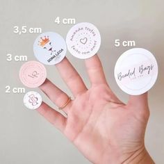 a person's hand with four different types of stickers on the thumb and two fingers