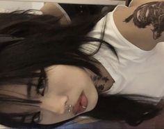 a woman with tattoos on her arm laying down