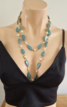 A pretty necklace of very light faux turquoise and pearl beads with gold tone wire spacing. The necklace is very versatile and can be worn as a single strand, wound around the neck or indeed as a two string necklace. The necklace measures 120 cm/47 inches Condition Being a vintage piece, any notable damage, missing parts or wear will be described as accurately as possible. However, minor imperfections & signs of wear should be expected. Please consider pictures provided as part of the descriptio Elegant Turquoise Wire Wrapped Beaded Necklace, Turquoise Beaded Pearl Necklaces With Pearl Chain, Turquoise Pearl Beaded Necklaces With Pearl Chain, Elegant Double Strand Turquoise Necklace, Elegant Double Strand Turquoise Beaded Necklace, Elegant Turquoise Double Strand Beaded Necklaces, Elegant Turquoise Beaded Necklaces With Pearl Chain, Turquoise Pearl Necklace With Round Beads, Elegant Long Beaded Turquoise Necklace