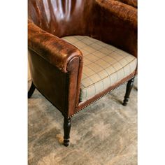 a brown leather chair sitting on top of a carpeted floor