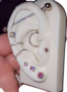 a person is holding a fake ear with jewels on it