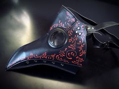 Our black plague mask with red hand-painted filigree detailing will take you back to the historical plague era. Our mask is crafted with vegan leather, making it perfect for cosplay and events as the material is breathable and comfortable to wear for long periods of time. Black/Red Color. Age Group/Gender - Adult/Unisex Size/Type - One size fits all adults Mask Color - Black Filigree Color - Red Mask Material - Vegan Leather Black Plague Mask, Doctor Inspiration, Plague Doctor Masks, Black Plague Doctor, Beak Mask, Black Plague, Plague Mask, Plague Doctor Mask, Doctor Mask